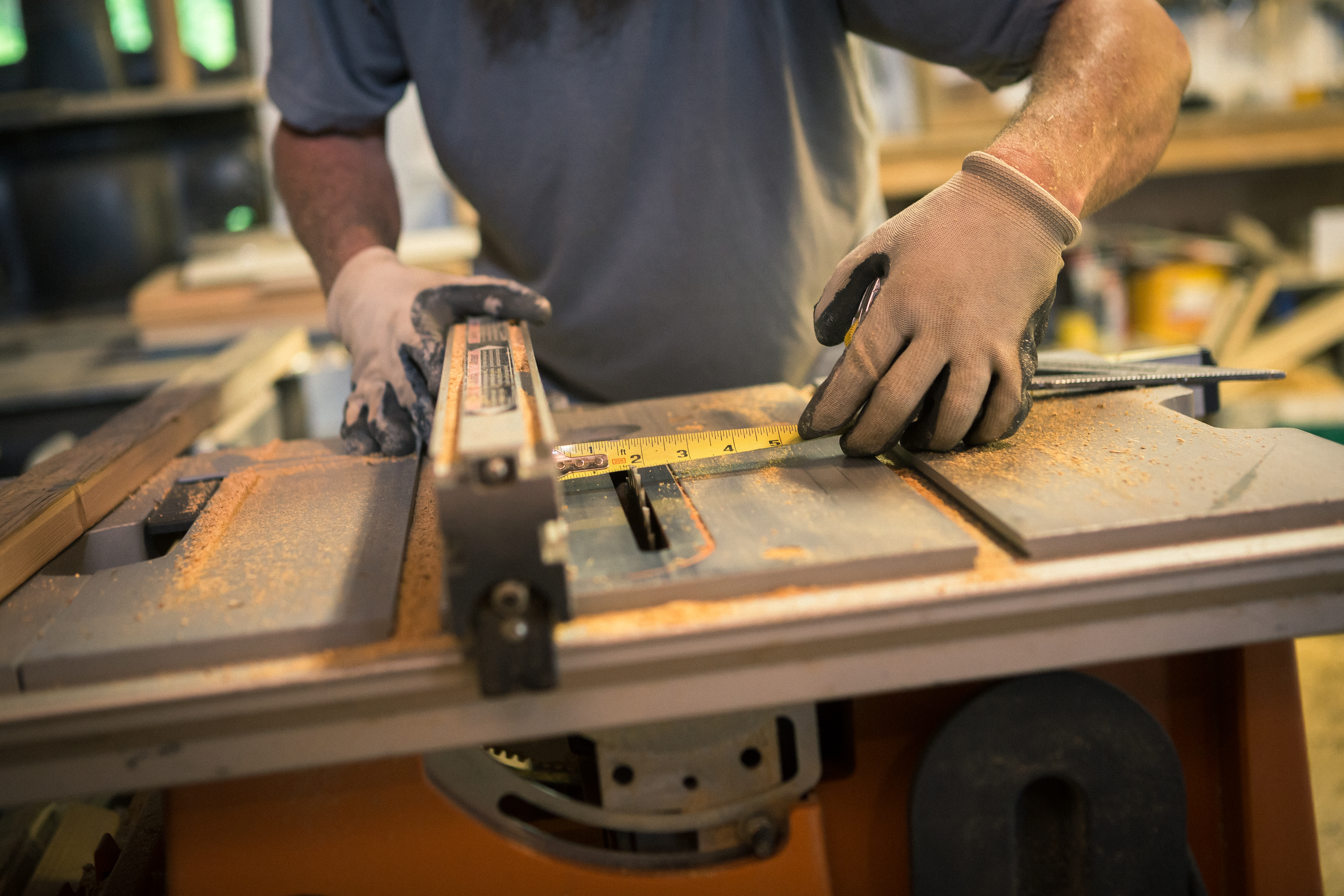 Wood artist in workshop, using woodworking machinery, mid section