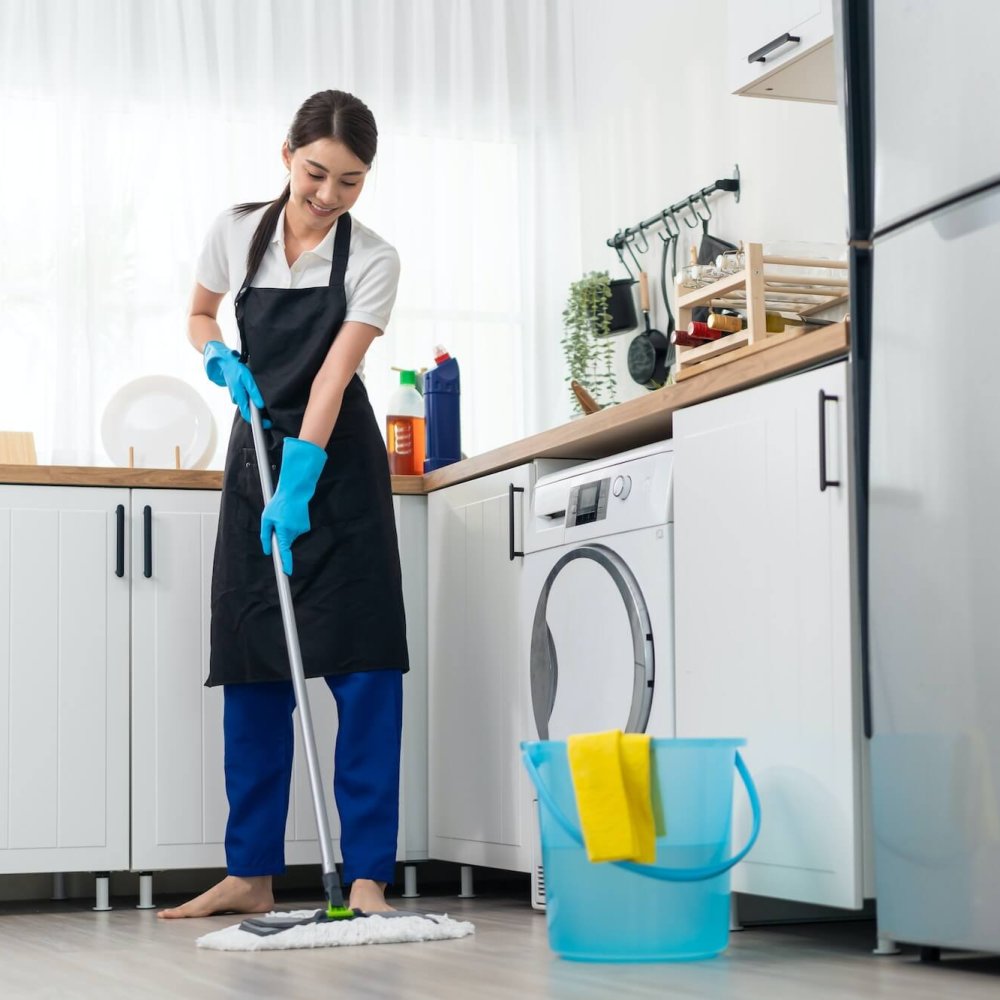 Asian active cleaning service woman worker cleaning in kitchen at home.